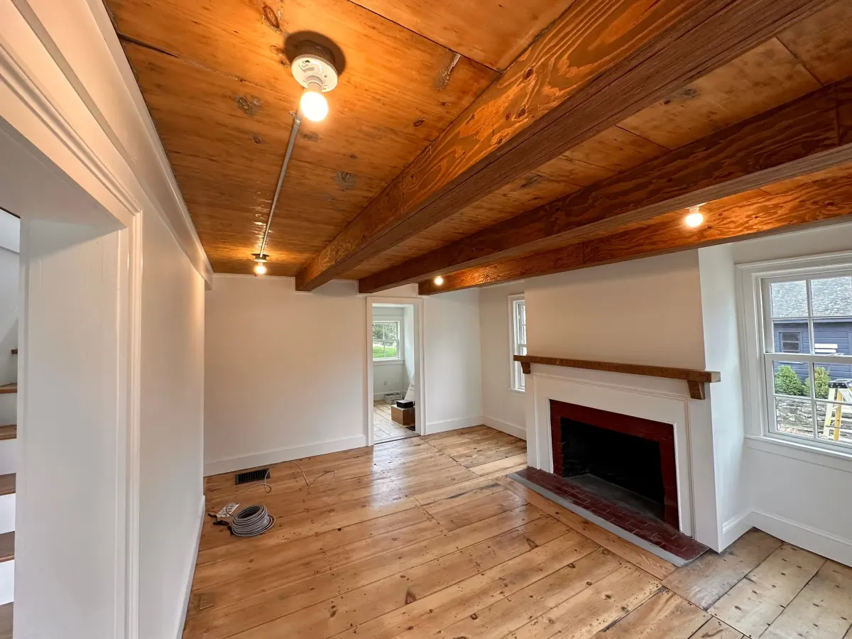 Residential room renovation with new lighting installation and exposed beam ceiling